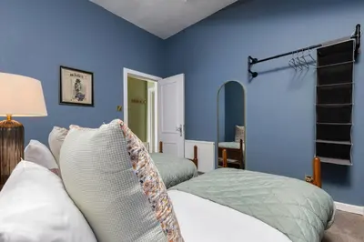 a bedroom with two beds and blue walls at Elegant 3 Bed Apartment in Stirling Near Free Parking and Hill Views in Stirling