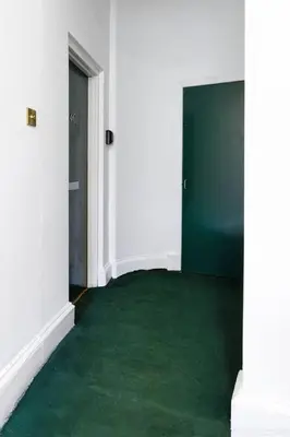 an empty room with green carpet and two doors at Elegant 3 Bed Apartment in Stirling Near Free Parking and Hill Views in Stirling