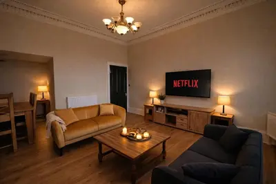a living room with a couch and a tv at Contractors and Guests Grand 3 Bedroom Central Free Parking Fully equipped in Glasgow