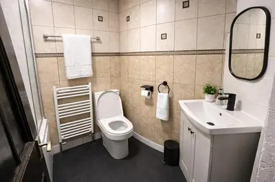 a bathroom with a toilet and a sink and a mirror at Contractors and Guests Grand 3 Bedroom Central Free Parking Fully equipped in Glasgow