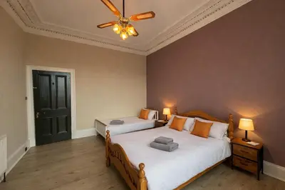 a bedroom with two beds and a ceiling fan at Contractors and Guests Grand 3 Bedroom Central Free Parking Fully equipped in Glasgow