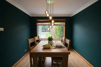 a dining room with a table with a bowl of fruit on it at Comfortable 3 Bed Home with Garden & Parking Stylish Family Contractor in Newton Mearns