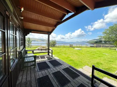 a porch with benches and a view of the water at Craig Na Barnach in Furnace
