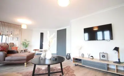 a living room with a couch and a table at Stylish 2 Bed Duplex with Balcony & Parking Merchant City in Glasgow