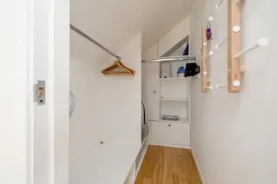 a hallway with white walls and a white closet at Barnton Grove Getaway in Edinburgh