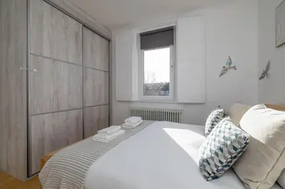 a bedroom with a large white bed and a window at Barnton Grove Getaway in Edinburgh