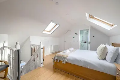 a white bedroom with a bed and a skylight at Barnton Grove Getaway in Edinburgh