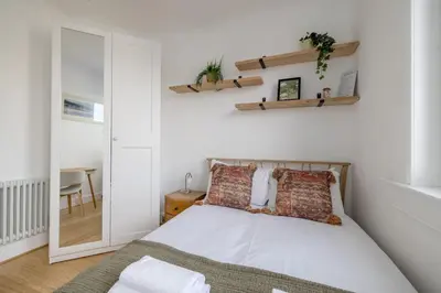 a bedroom with a bed and a mirror at Barnton Grove Getaway in Edinburgh