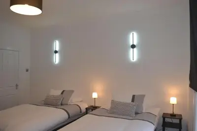 two beds in a room with lights on the wall at Large 8 Bed Group and Contractor Accommodation in Stirling