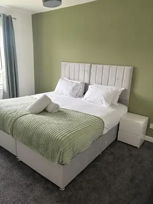 a bedroom with a large bed with white sheets and pillows at Home in Glasgow3BR -Ziplinks - Sleeps 6 G51 in Glasgow