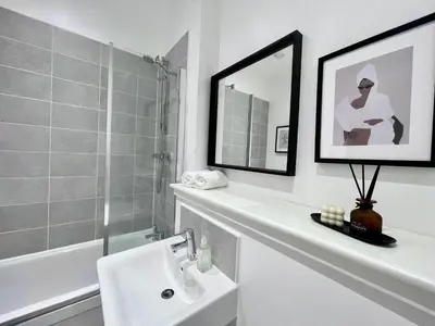 a white bathroom with a sink and a mirror at WHITE LOFT - Modern flat close to the City Centre in Edinburgh
