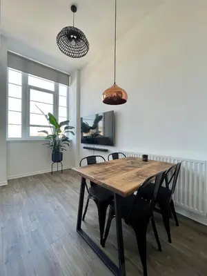 a dining room with a wooden table and chairs at WHITE LOFT - Modern flat close to the City Centre in Edinburgh