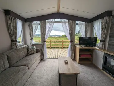 a living room with a couch and a tv and a table at Swift Bordeaux Sea View No 2 in Dunoon