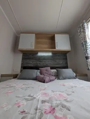 a bedroom with a large bed with pink flowers on it at Swift Bordeaux Sea View No 2 in Dunoon