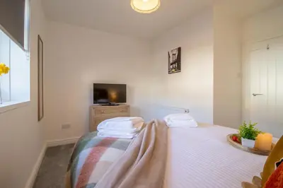 a bedroom with a bed with a blanket on it at Betty's House - 3 bedroom in Coatbridge in Glenboig
