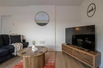 a living room with a couch and a large flat screen tv at Betty's House - 3 bedroom in Coatbridge in Glenboig