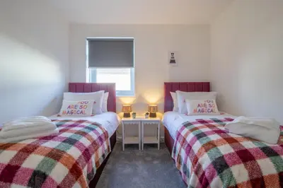 two beds sitting next to each other in a room at Betty's House - 3 bedroom in Coatbridge in Glenboig