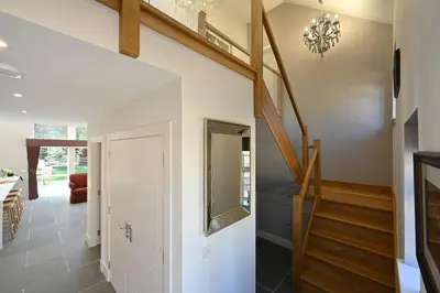 a hallway with a staircase in a house at Kennels Cottage in Buchanty