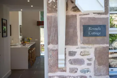 a stone wall in a kitchen with a sign on it at Kennels Cottage in Buchanty