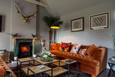 a living room with a couch and a fireplace at The Painted Cow in Beattock