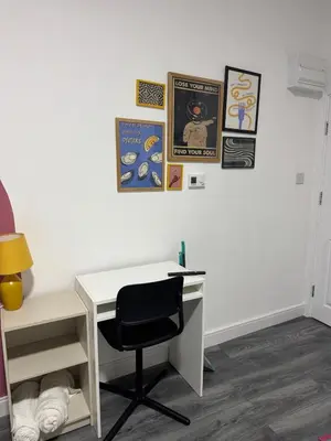 a desk and a chair in a room with pictures on the wall at #127 Modern City Suite Digbeth Creative Quarter in Moffat