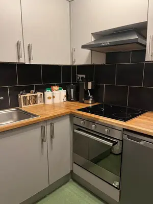 a kitchen with white cabinets and a stove top oven at Lovely Apartment by Meadows 1 in Edinburgh