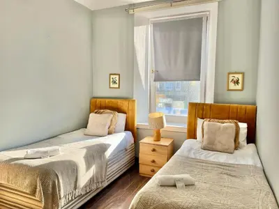 two beds in a small room with a window at Lovely Apartment by Meadows 1 in Edinburgh