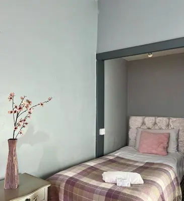 a bedroom with a bed with a vase of flowers at Lovely Apartment by Meadows 1 in Edinburgh