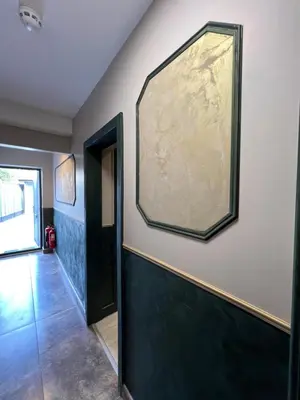 a hallway with a large painting on the wall at Rest Inn Edmonton in Moffat