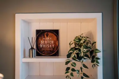 a shelf with a book and a plant in a room at Sea View, 2 Bed Apartment, Central Largs in Largs