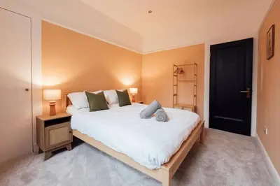 a bedroom with a large white bed and a black door at Sea View, 2 Bed Apartment, Central Largs in Largs