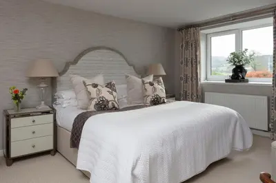 a bedroom with a white bed with pillows and a window at Stylish Retreat Auchterarder in Auchterarder