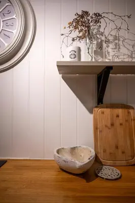 a bowl sitting on a wooden floor next to a clock at Tegfryn in Moffat