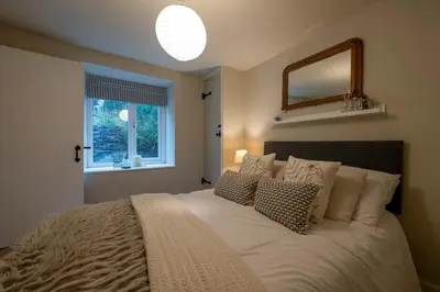 a bedroom with a large bed with pillows and a window at Tegfryn in Moffat