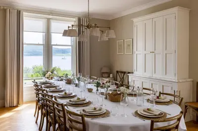 a long dining room with a long table and chairs at The Hollies Argyll in Tighnabruaich