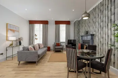 a living room with a couch and a table at Destiny Scotland - Princes Street Residence in Edinburgh