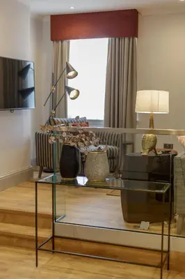a living room with a glass table and a couch at Destiny Scotland - Princes Street Residence in Edinburgh