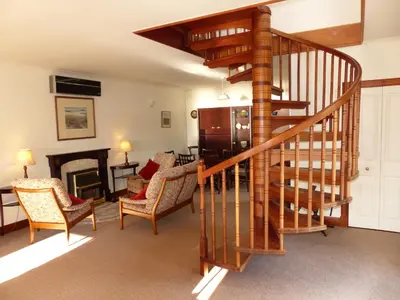 a living room with a spiral staircase and a living room at Blarghour Farm Cottages in Ardchonnell