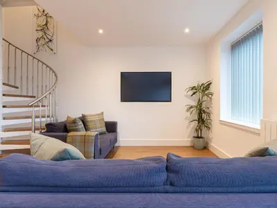 a living room with a couch and a tv on a wall at CITY CENTRE APARTMENT with Free Secure Underground Parking in Glasgow