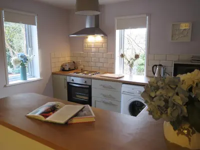 a kitchen with a wooden table with a book on it at Elmbank Garden Apartment in Oban