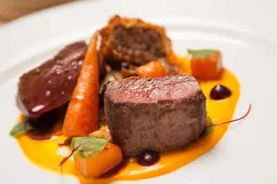 a plate of food with meat and carrots on a plate at The Bridge Inn in Ratho