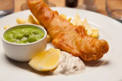 a plate of food with fish and chips and dip at The Bridge Inn in Ratho