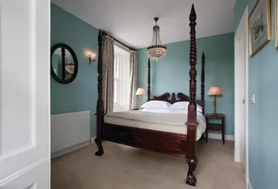 a bedroom with a canopy bed in a blue room at The Bridge Inn in Ratho
