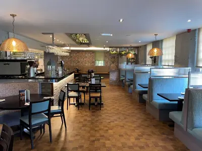 a restaurant with tables and chairs and a bar at The Grange Manor in Grangemouth