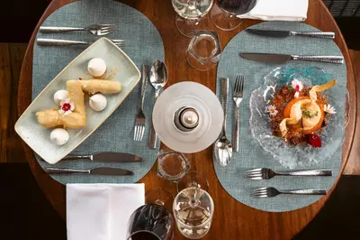 a wooden table with a plate of food and silverware at The Isles of Glencoe Hotel in Glencoe