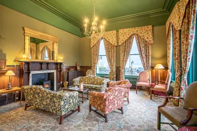 a living room with chairs and a fireplace at The Ballachulish Hotel in Glencoe