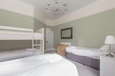 a bedroom with two bunk beds and a chandelier at Rose Street Residence in Edinburgh