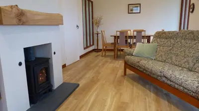 a living room with a couch and a fireplace at Blarghour Farm Cottages Overlooking Loch Awe in Ardchonnell