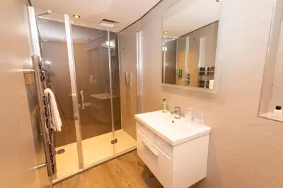 a bathroom with a shower and a white sink at Court Residence Aparthotel in Linlithgow