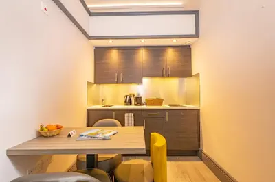 a kitchen with a table with chairs and a counter top at Court Residence Aparthotel in Linlithgow